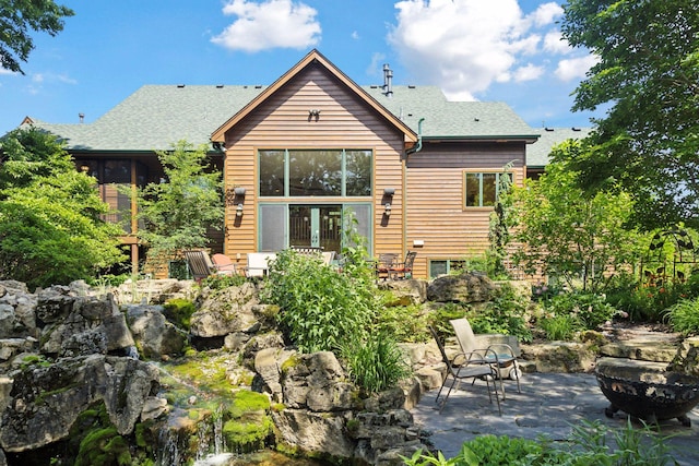 9449 Ehler Ave SE, Delano, MN 55328 - back of property featuring a patio, roof with shingles, and an outdoor fire pit