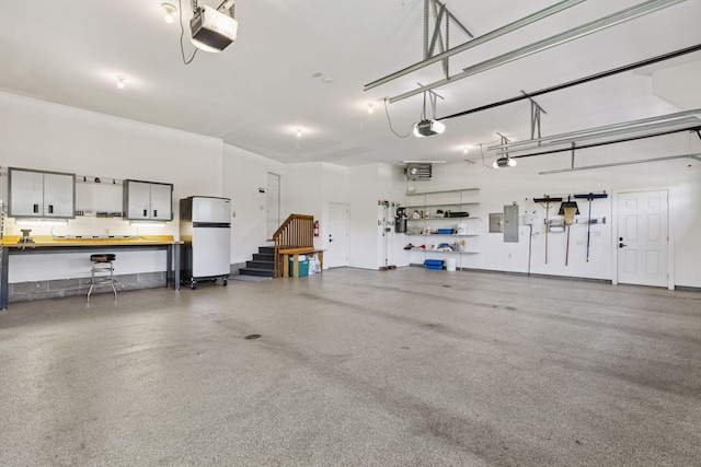9449 Ehler Ave SE, Delano, MN 55328 - garage featuring freestanding refrigerator, a heating unit, electric panel, and a garage door opener
