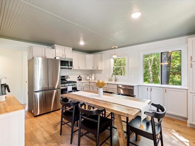 12698 Omega Ln, Center Twp, MN 56465 - kitchen featuring appliances with stainless steel finishes, decorative backsplash, white cabinetry, light wood-style flooring, and recessed lighting
