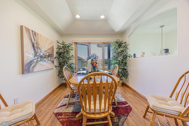17123 Lakeview Ln, Audubon, MN 56511 - dining room with arched walkways, light wood-style floors, recessed lighting, a tray ceiling, and vaulted ceiling