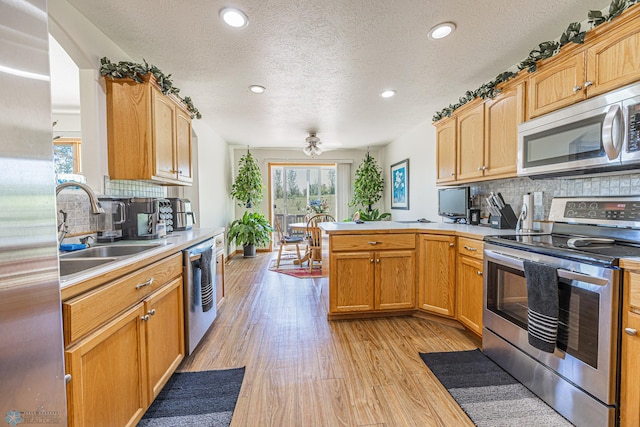 17123 Lakeview Ln, Audubon, MN 56511 - kitchen with appliances with stainless steel finishes, a peninsula, light wood-style flooring, light countertops, and recessed lighting