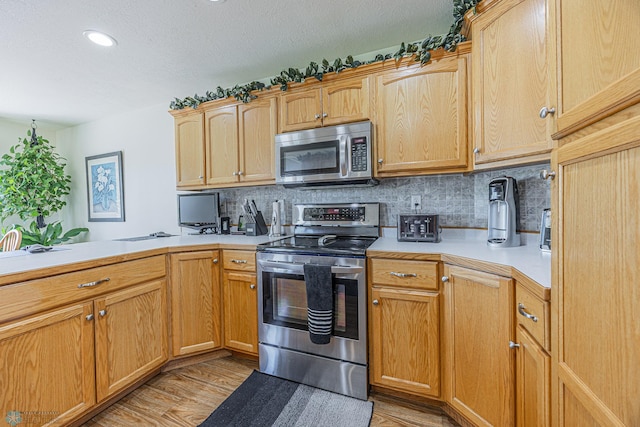 17123 Lakeview Ln, Audubon, MN 56511 - kitchen with stainless steel appliances, light countertops, tasteful backsplash, light wood-style flooring, and recessed lighting