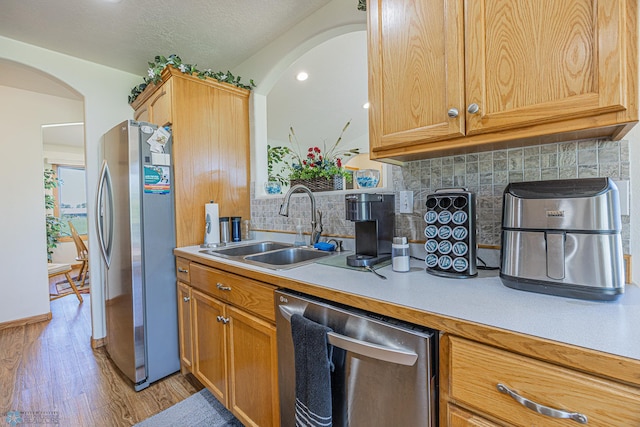17123 Lakeview Ln, Audubon, MN 56511 - kitchen with stainless steel appliances, light countertops, light wood finished floors, tasteful backsplash, and arched walkways