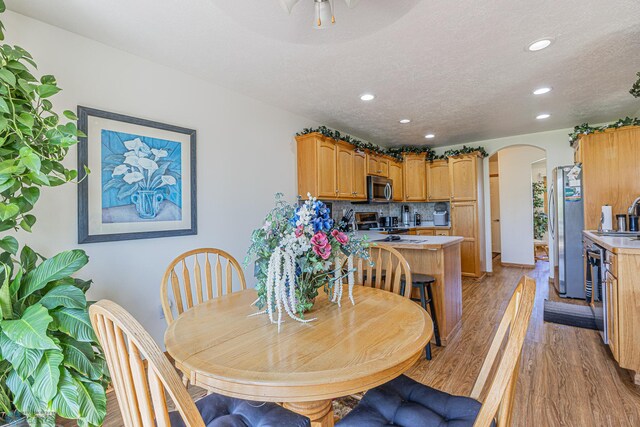 17123 Lakeview Ln, Audubon, MN 56511 - dining room featuring arched walkways, light wood-style floors, recessed lighting, and a textured ceiling