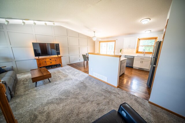 724 50th Ave NW, Rochester, MN 55901 - living room with a ceiling fan, dark colored carpet, lofted ceiling, and dark wood-type flooring