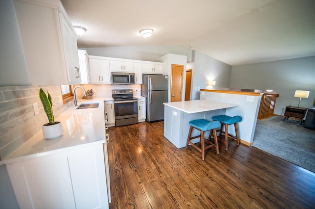 724 50th Ave NW, Rochester, MN 55901 - kitchen with stainless steel appliances, a breakfast bar area, light countertops, white cabinets, and vaulted ceiling
