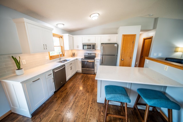 724 50th Ave NW, Rochester, MN 55901 - kitchen with appliances with stainless steel finishes, a breakfast bar area, lofted ceiling, white cabinetry, and decorative backsplash