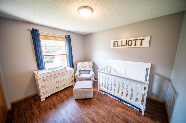 724 50th Ave NW, Rochester, MN 55901 - bedroom featuring wood finished floors, a textured ceiling, and a nursery area