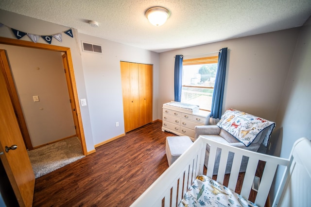 724 50th Ave NW, Rochester, MN 55901 - bedroom with dark wood-style flooring, a textured ceiling, and a closet