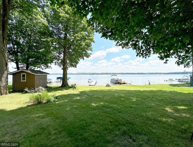 11436 Hoyer Ave NW, Annandale, MN 55302 - view of green lawn with a water view, a boat dock, and an outbuilding