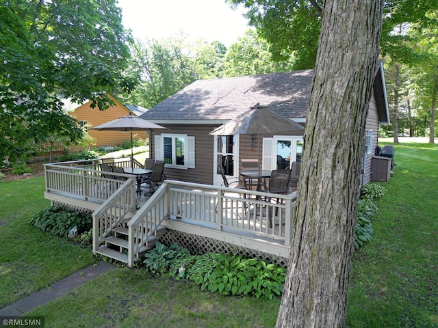 11436 Hoyer Ave NW, Annandale, MN 55302 - back of property featuring roof with shingles, a lawn, a wooden deck, and outdoor dining area