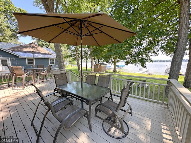 11436 Hoyer Ave NW, Annandale, MN 55302 - deck with outdoor dining area, a storage shed, and a water view