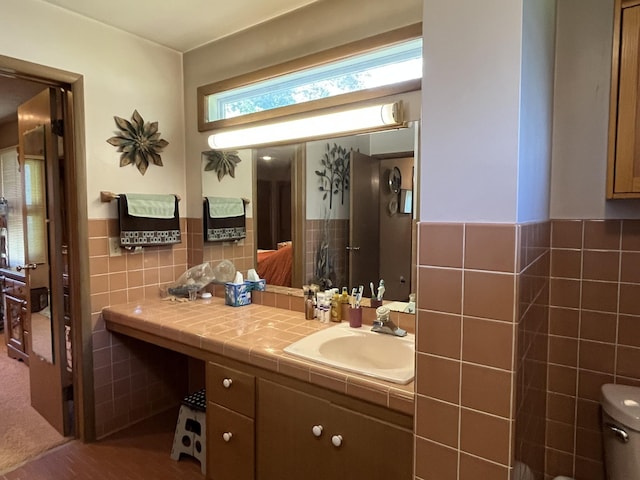 806 Highland Rd, Windom, MN 56101 - bathroom featuring tile walls, vanity, ensuite bathroom, and wainscoting