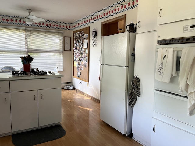 806 Highland Rd, Windom, MN 56101 - kitchen featuring white appliances, a ceiling fan, and wood finished floors