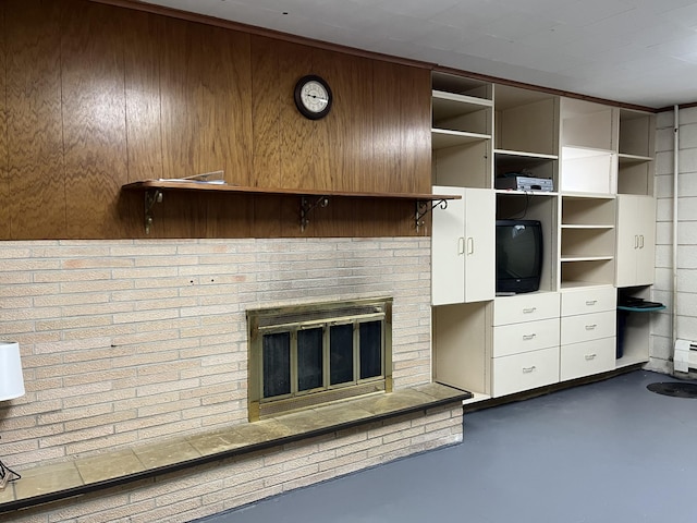 806 Highland Rd, Windom, MN 56101 - unfurnished living room with finished concrete floors, a brick fireplace, wooden walls, and baseboard heating