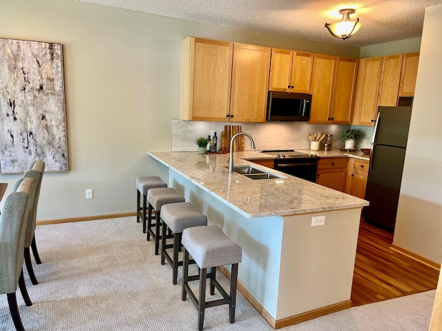 2100 Old School Rd Unit 206, Mound, MN 55364 - kitchen featuring stainless steel appliances, a breakfast bar area, decorative backsplash, light stone counters, and a peninsula