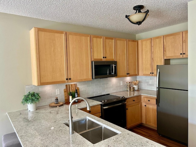 2100 Old School Rd Unit 206, Mound, MN 55364 - kitchen featuring stainless steel appliances, light stone countertops, a peninsula, decorative backsplash, and a textured ceiling