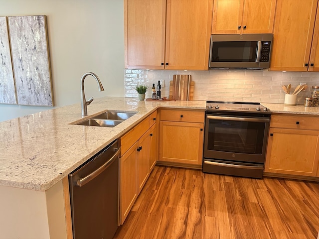 2100 Old School Rd Unit 206, Mound, MN 55364 - kitchen with stainless steel appliances, light wood-type flooring, backsplash, and light stone counters