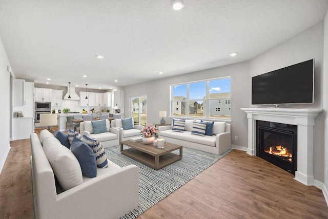 898 Laurel Ct, Chaska, MN 55318 - living room with wood finished floors, a glass covered fireplace, and recessed lighting