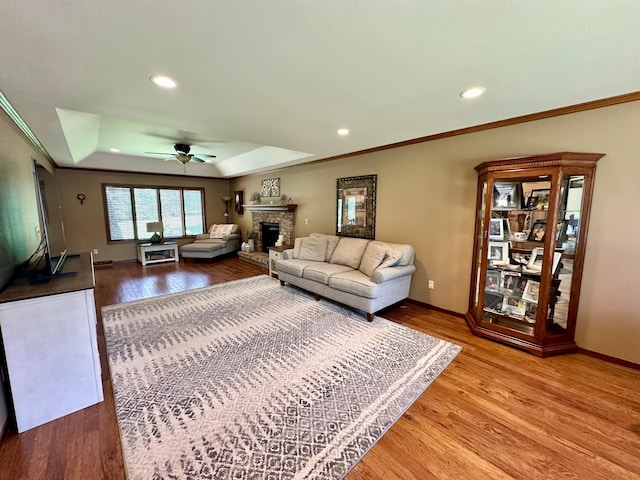 1201 Morningside Cir, Marshall, MN 56258 - living area featuring a raised ceiling, ceiling fan, wood finished floors, a fireplace with raised hearth, and recessed lighting