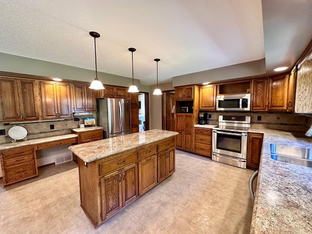 1201 Morningside Cir, Marshall, MN 56258 - kitchen featuring appliances with stainless steel finishes, a kitchen island, backsplash, and brown cabinets