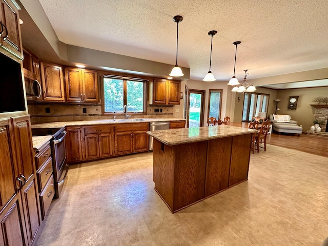 1201 Morningside Cir, Marshall, MN 56258 - kitchen with stainless steel appliances, a textured ceiling, plenty of natural light, brown cabinets, and a kitchen island