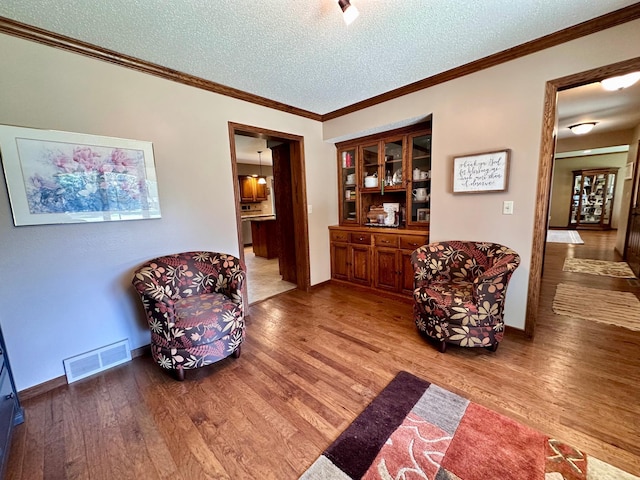 1201 Morningside Cir, Marshall, MN 56258 - sitting room featuring a textured ceiling, wood finished floors, and crown molding