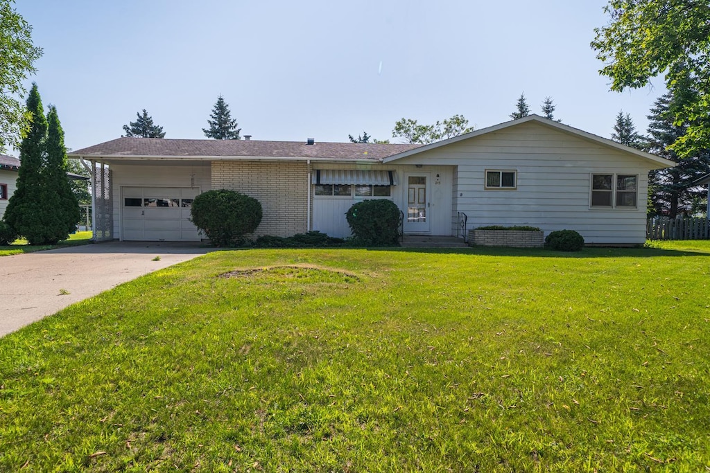 215 Charles Ave, Detroit Lakes, MN 56501 - ranch-style house featuring an attached garage, a front yard, driveway, and brick siding