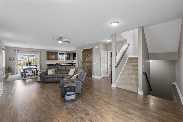 7850 242nd St, Wyoming, MN 55025 - living area with a barn door, dark wood-style flooring, a chandelier, a ceiling fan, and stairs