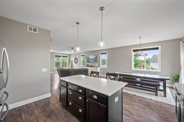 7850 242nd St, Wyoming, MN 55025 - kitchen featuring dark wood finished floors, light countertops, hanging light fixtures, a center island, and ceiling fan