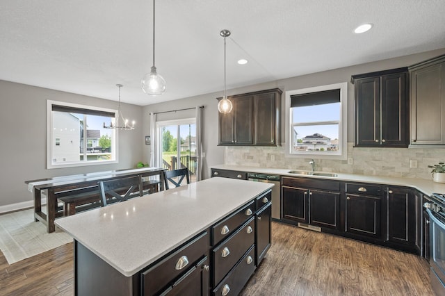 7850 242nd St, Wyoming, MN 55025 - kitchen featuring dishwasher, dark wood-style floors, decorative backsplash, a chandelier, and a center island