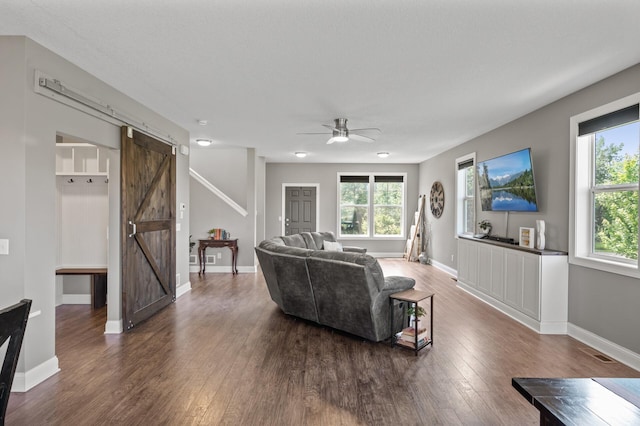 7850 242nd St, Wyoming, MN 55025 - living area with a barn door, wood finished floors, plenty of natural light, and a ceiling fan