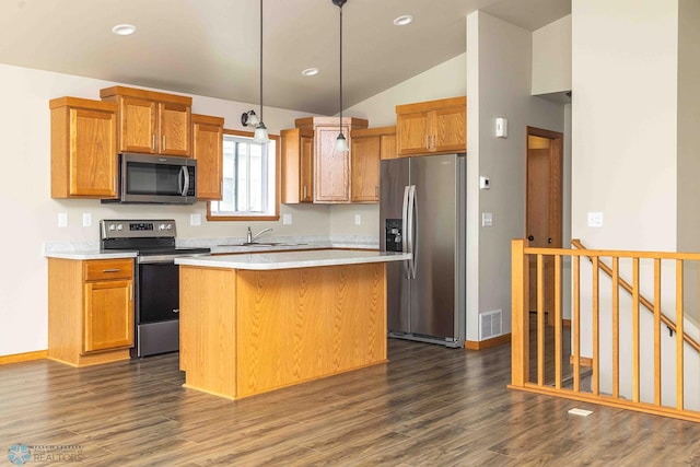 2054 12th St W, West Fargo, ND 58078 - kitchen featuring appliances with stainless steel finishes, lofted ceiling, a kitchen island, dark wood-style flooring, and light countertops