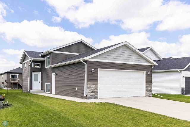 2054 12th St W, West Fargo, ND 58078 - view of front of home featuring concrete driveway, a garage, a front yard, and stone siding