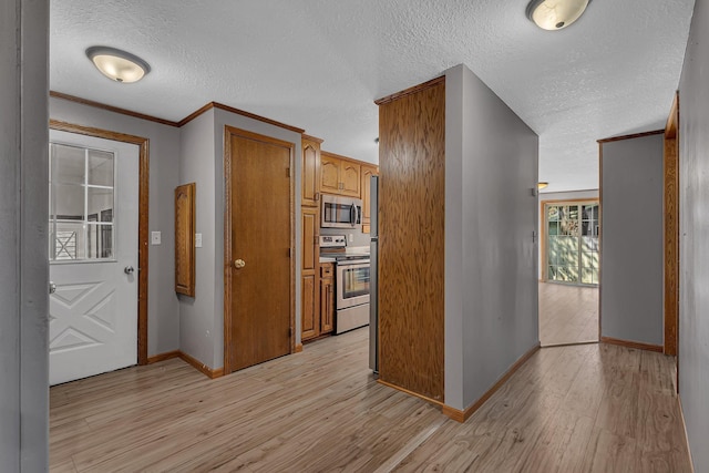 9353 Ideal Rd, Watab Twp, MN 56367 - kitchen with stainless steel appliances, a textured ceiling, light wood-style flooring, brown cabinets, and crown molding