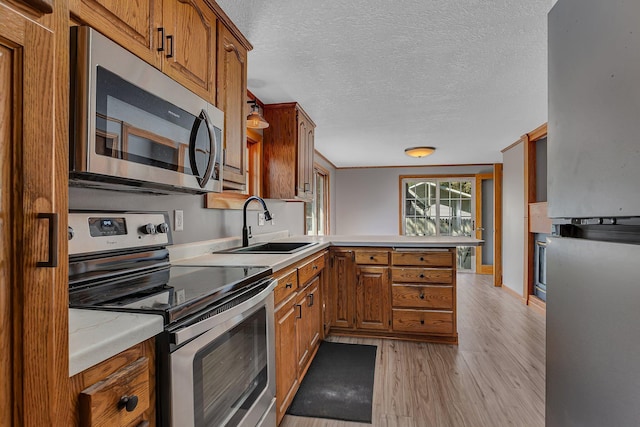 9353 Ideal Rd, Watab Twp, MN 56367 - kitchen with stainless steel appliances, a peninsula, light countertops, a textured ceiling, and brown cabinets