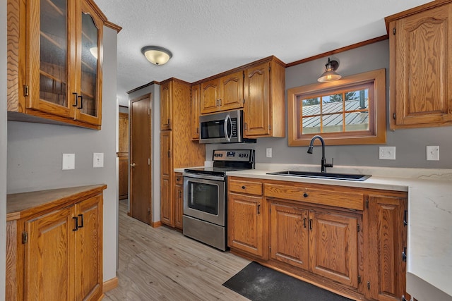 9353 Ideal Rd, Watab Twp, MN 56367 - kitchen featuring stainless steel appliances, brown cabinets, light countertops, light wood-type flooring, and a textured ceiling