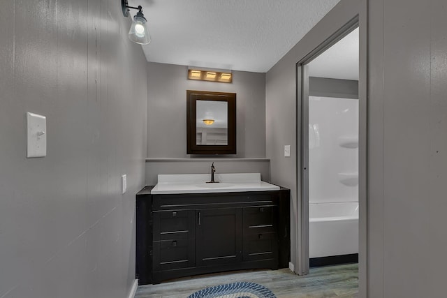 9353 Ideal Rd, Watab Twp, MN 56367 - bathroom featuring wood finished floors, vanity, and a textured ceiling
