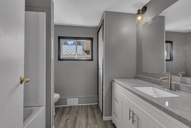 9353 Ideal Rd, Watab Twp, MN 56367 - full bathroom with vanity, wood finished floors, a tub to relax in, and a textured ceiling