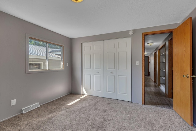 9353 Ideal Rd, Watab Twp, MN 56367 - unfurnished bedroom featuring carpet, a closet, and a textured ceiling