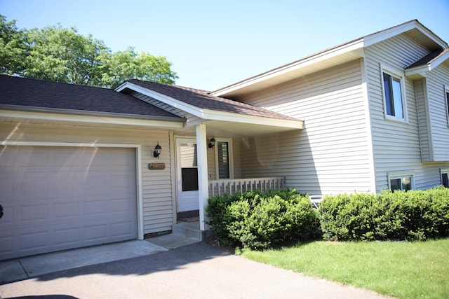 3930 99th Ave NE, Blaine, MN 55014 - view of front of property with a garage, a porch, and roof with shingles