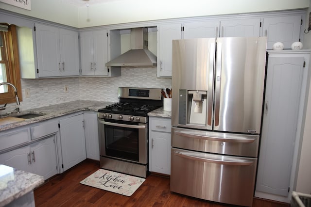 3930 99th Ave NE, Blaine, MN 55014 - kitchen with appliances with stainless steel finishes, wall chimney exhaust hood, backsplash, and dark wood finished floors