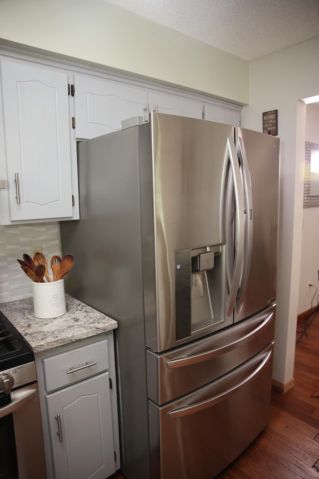 3930 99th Ave NE, Blaine, MN 55014 - kitchen featuring appliances with stainless steel finishes, dark wood finished floors, tasteful backsplash, white cabinets, and a textured ceiling