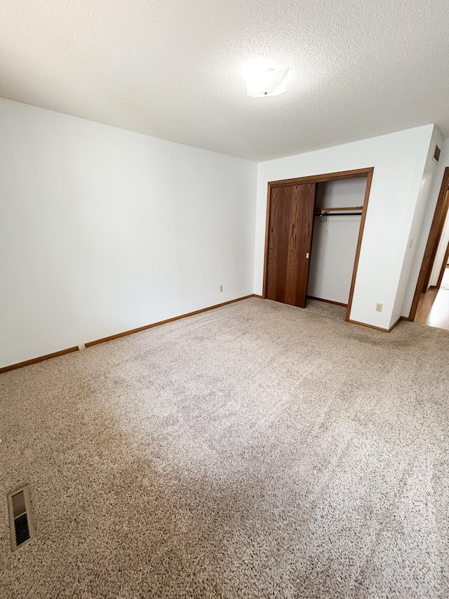 428 16th St, Windom, MN 56101 - unfurnished bedroom featuring light colored carpet, a closet, and a textured ceiling