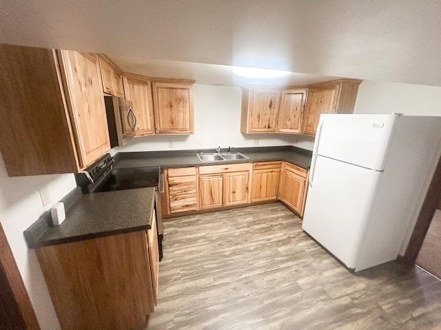 428 16th St, Windom, MN 56101 - kitchen with freestanding refrigerator, black range with electric stovetop, stainless steel microwave, dark countertops, and light brown cabinetry