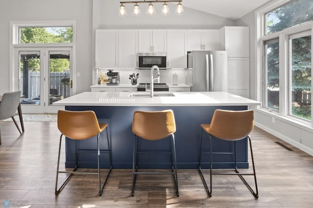 3501 19th St S, Fargo, ND 58104 - kitchen with stainless steel appliances, plenty of natural light, a center island with sink, wood finished floors, and vaulted ceiling