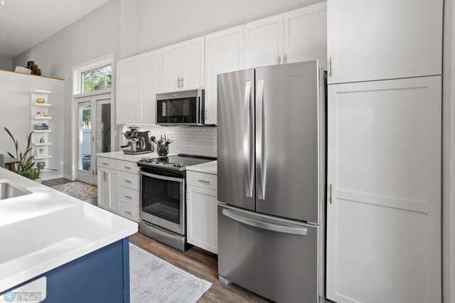 3501 19th St S, Fargo, ND 58104 - kitchen featuring appliances with stainless steel finishes, decorative backsplash, light countertops, white cabinetry, and wood finished floors