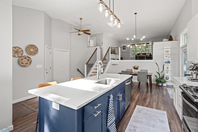 3501 19th St S, Fargo, ND 58104 - kitchen featuring blue cabinetry, appliances with stainless steel finishes, ceiling fan, dark wood finished floors, and a chandelier