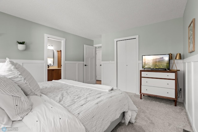 3501 19th St S, Fargo, ND 58104 - carpeted bedroom with a wainscoted wall, a closet, a textured ceiling, and ensuite bath