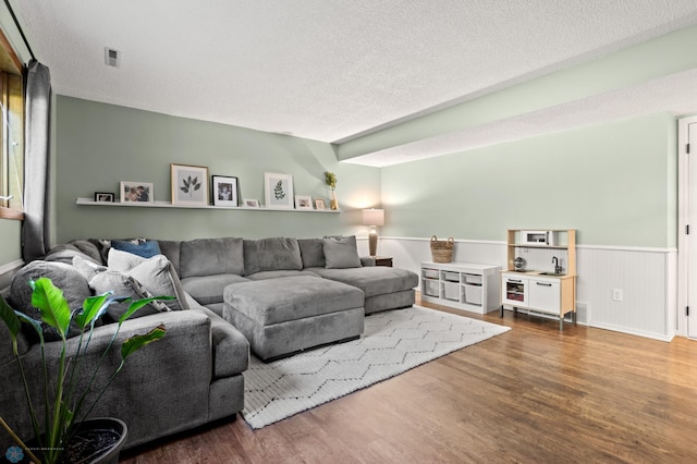 3501 19th St S, Fargo, ND 58104 - living room featuring wood finished floors, wainscoting, and a textured ceiling
